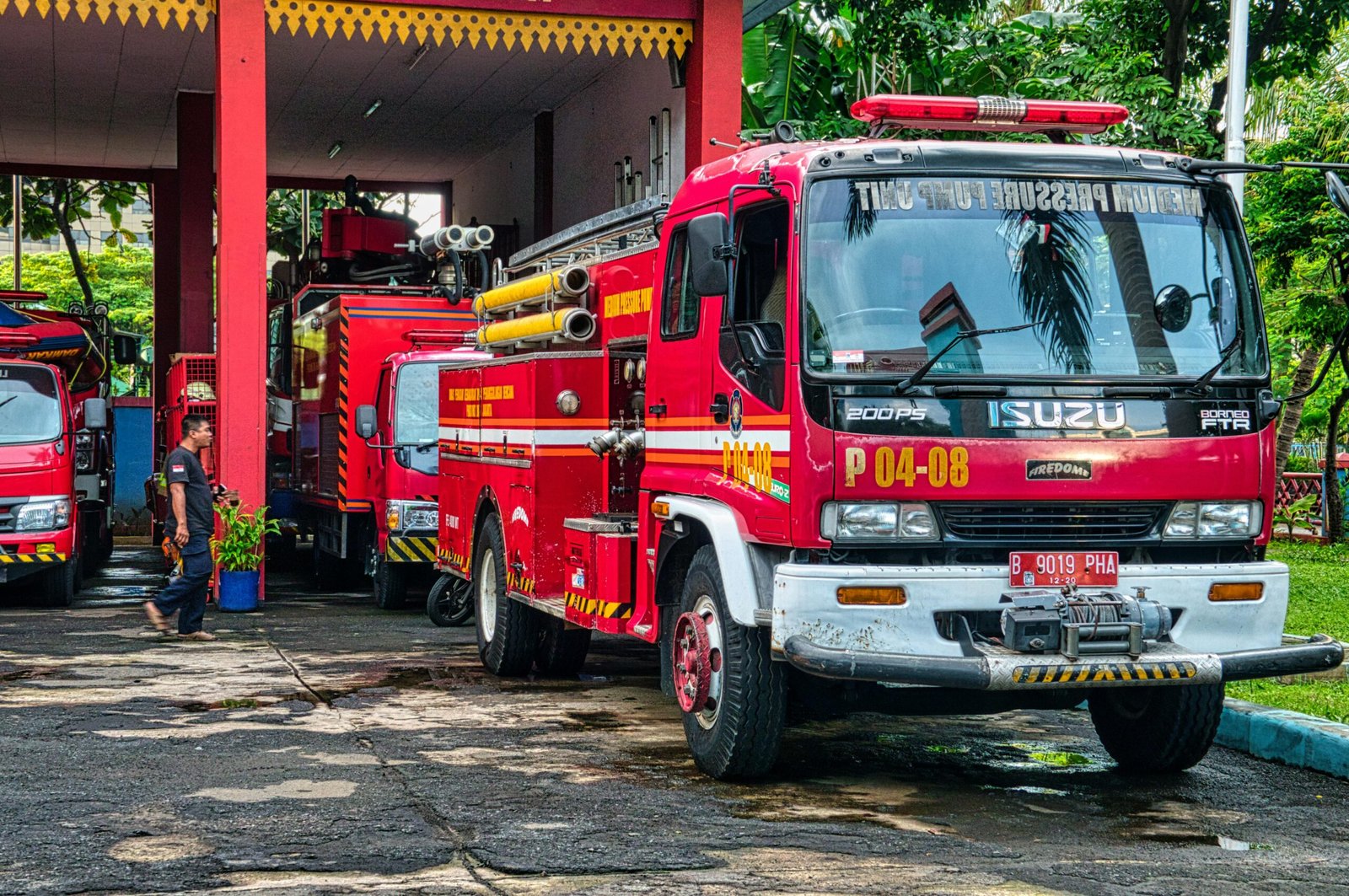 Fire trucks parked at an outdoor fire station in Jakarta, Indonesia during the day.