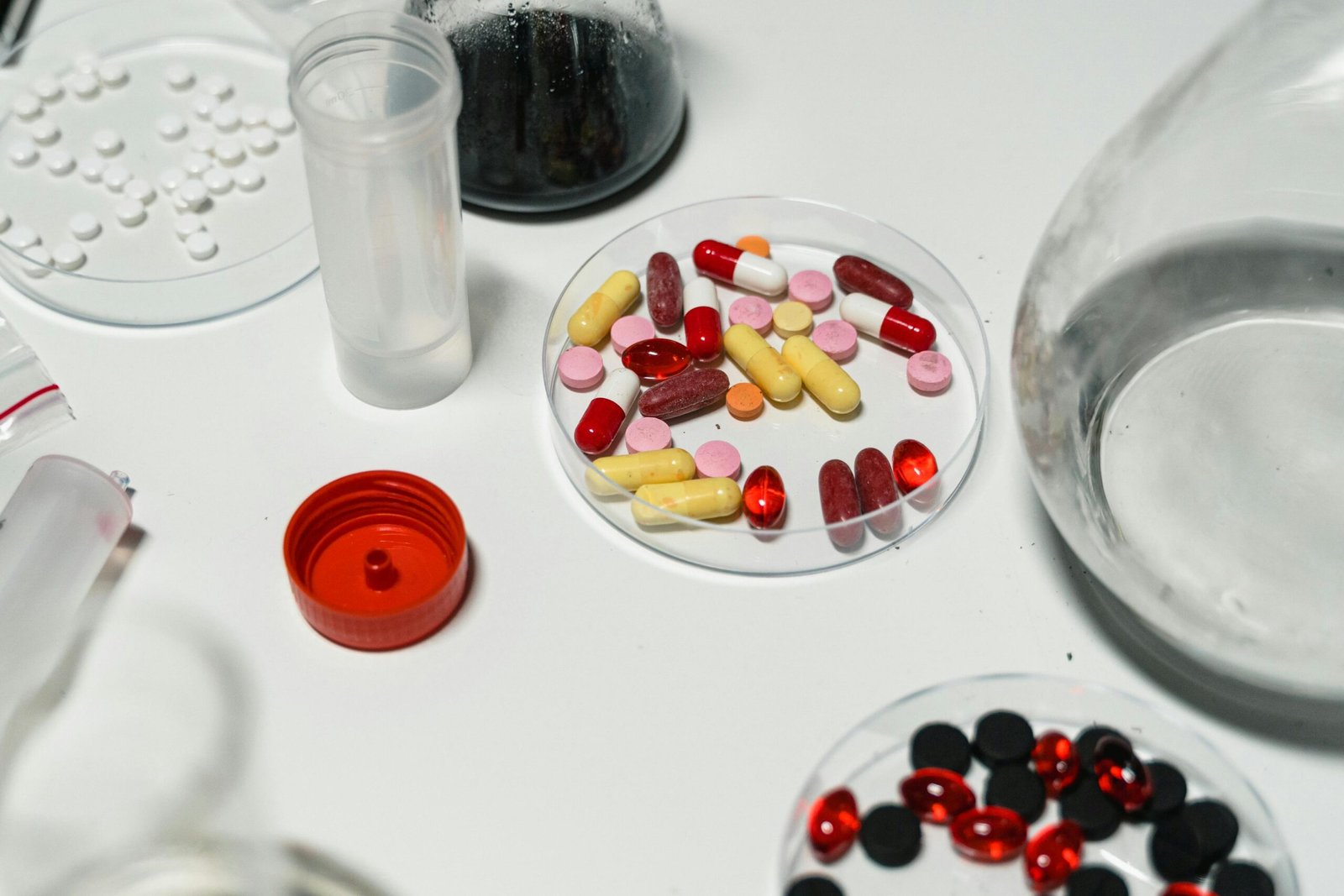 Assorted pills and capsules arranged on a lab table, emphasizing pharmacology and medicine.